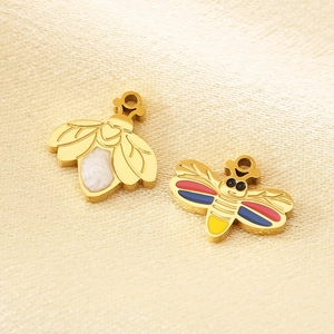 Detailed view of golden stainless steel bee pendants with colorful enamel on beige silk