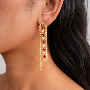 Detail view of 18k gold plated long fringe earrings with red and white zircon stones