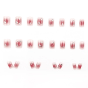 Pink blush gradient press-on nails with silver star patterns and sparkling rhinestones