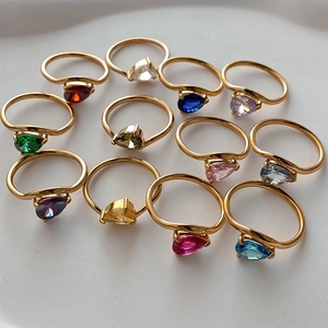 Detailed view of twelve gold rings with pear-cut colorful zircon stones in various shades