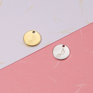 Close-up of gold and silver round music note pendants in mirror-finish titanium steel