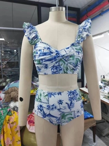 Detail of high waisted bikini set with blue tropical floral print and ruffle trim edges