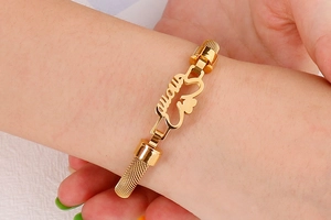 Detail of gold titanium steel mesh bracelet featuring MOM letter and heart hollow design