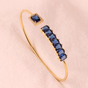 Detail van verstelbare gouden armband met blauwe edelstenen en micro-zirkonia's