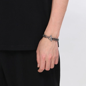 Détail d'un bracelet gourmette en acier rétro avec fermoir OT sur poignet masculin