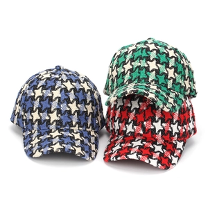 Detailed view of thick tweed baseball caps in blue, green, and red houndstooth patterns