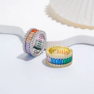 Gold and silver 925 sterling silver rings with colorful rainbow gemstones set on white surface