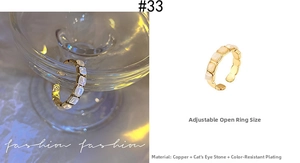Detailed view of adjustable gold-plated ring featuring square opal stones on a glass edge