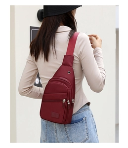 Rear view of model wearing a stylish red oxford fabric crossbody chest bag with strap