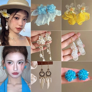 Detail of floral chiffon tassel earrings with acrylic petals and bohemian style charms