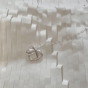 Minimalist 925 sterling silver heart pendant necklace on modern textured white background