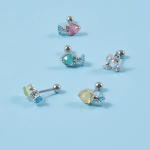 Detailed macro view of heart and crown shaped ear studs with colorful resin opals