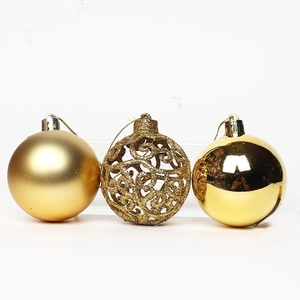 Three gold Christmas tree balls in matte, hollow glitter, and glossy styles on white