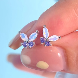 Close-up of butterfly stud earrings with purple marquise cut stones and gold plating