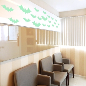 Luminous green bat wall stickers set arranged above waiting area chairs for Halloween