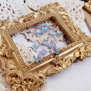 Macro shot of iridescent butterfly cartilage stud earring on vintage gold frame detail