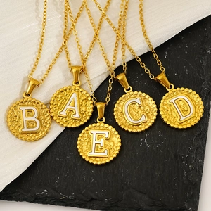 Hammered titanium steel gold necklaces with initial letters A to E on marble background