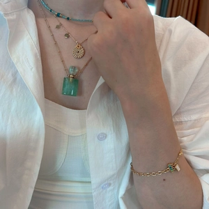 Layered natural stone and gold chain jewelry set with a mini perfume bottle pendant