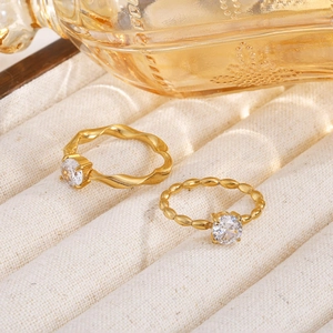 Detailed macro view of two gold Mobius rings with clear cubic zirconia on a jewelry tray