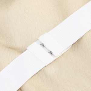 Détail des bretelles élastiques blanches et du crochet métallique de la robe en velours