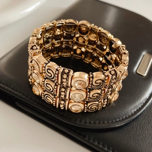 Vintage gold layered cuff bracelet with circular crystal accents on black leather