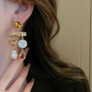 Detailed side view of baroque style earrings with amber crystals and pearl tassels