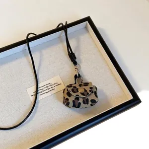 Mini borsa collana in pelle leopardata con cordino nero e chiusura metallica per donna