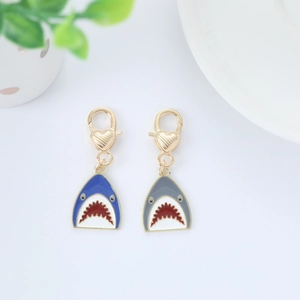 Detailed view of blue and grey metal shark keychains with golden heart-shaped lobster clasps