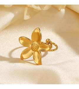 Detailed macro view of the golden flower stainless steel ring with wave texture on satin