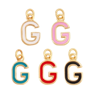 Detail of five gold-plated letter G pendants with colorful enamel inlays on white background