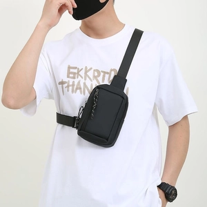 Minimalist black waterproof sling bag for men shown on model in urban outdoor style