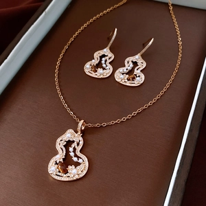 Detail of tiger eye and pearl gourd jewelry set showcased in a brown gift box