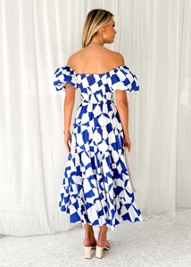 Vista posteriore di un vestito boho con spalle scoperte e stampe geometriche bianche e blu