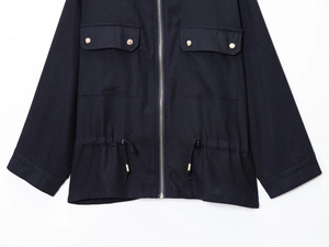 Detail of navy linen-blend jacket with silver metal zipper and flap pockets