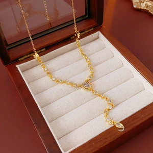 Detail of gold plated necklace with oval zircon and tassel in a velvet jewelry box