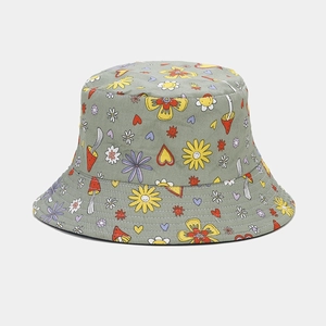 Close-up of canvas bucket hat with mushroom and floral print on light grey-green fabric