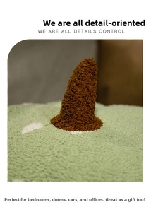 Close-up of soft green sherpa fabric with white dots and brown plush horn detail