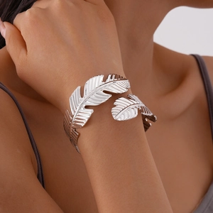 Detail of silver leaf cuff bracelet showing intricate metal texture on a woman's wrist