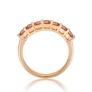 Detail of rose gold ring with seven pink moissanite stones in a row on white background