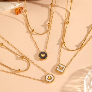 Detailed view of layered 18K gold-plated stainless steel necklaces with heart and butterfly charms