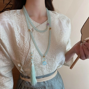 Detail of light blue glass bead necklace with tassel and Ping'an buckle for Hanfu dress