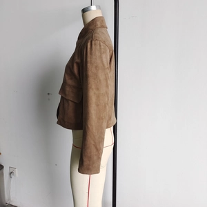 Détail d'une veste marron en daim avec poches latérales et coupe courte à revers