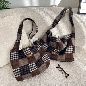 Dettaglio della borsa tote vintage in lana a quadri con maglia spessa ed etichetta in pelle