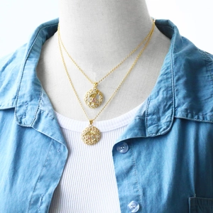 Detail of gold layered necklaces with girl silhouette and family figure pendants