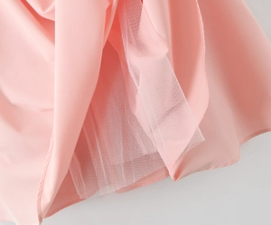 Detailopname van roze mesh en effen stofstiksels op een korsetjurk in Franse stijl