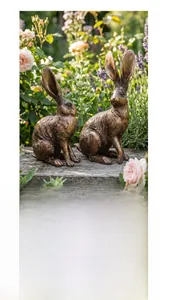 Detailopname van vintage bronzen konijnenbeelden met antieke texturen in de tuin