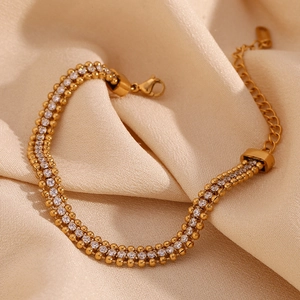 Detail of 18K gold-plated triple-row braided chain bracelet with white cubic zirconia
