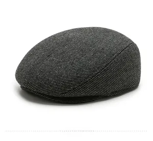 Detail view of the thick dark grey wool fabric and texture on the men's winter flat cap
