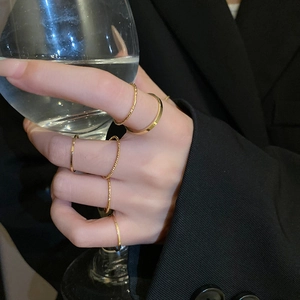 Detail of minimalist gold-tone stackable rings set worn by a model on hand