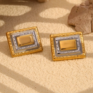 Detail of geometric rectangle earrings with 18K gold textured frame and silver accent